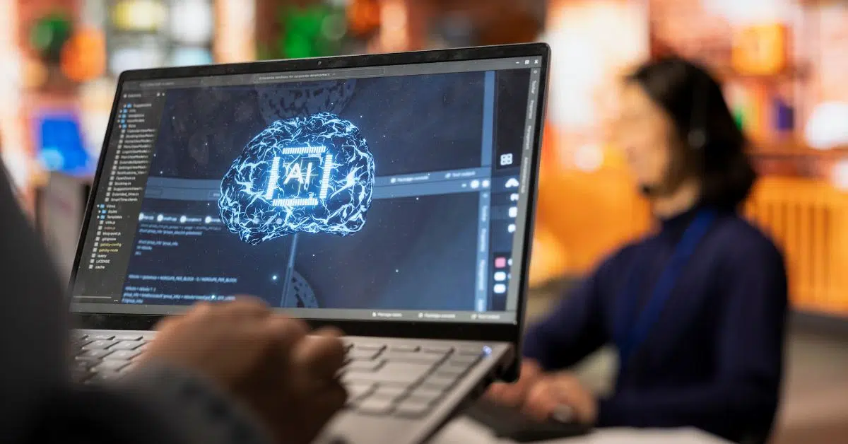 Close-up of a laptop screen showing a digital brain with AI circuits used for predictive programming.