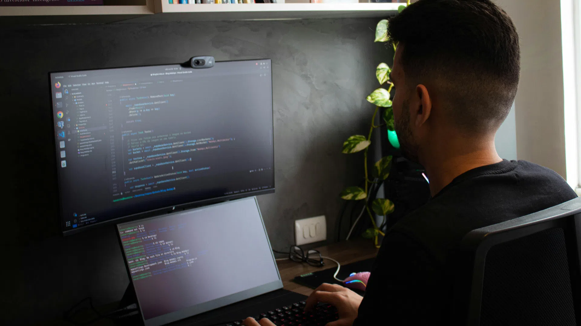 Male software developer coding on dual screens in a home office setup, representing Mexico’s remote development talent.